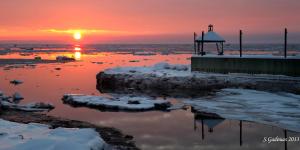 a sunset over a body of water with snow at Auberge de la rive de Charlevoix - Auberge familiale pour voyageurs de tous âges in Saint-Joseph-de-la-Rive