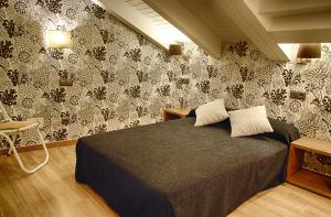 a bedroom with a bed with a black and white wallpaper at Le Petit León in León