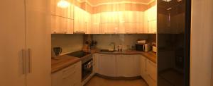 a kitchen with white cabinets and a black refrigerator at Vigo Luxe Apartment in Nesebar
