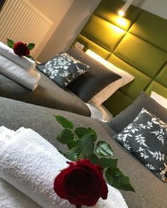 ワルシャワにあるPremium Apartment - Willa Parcのベッド2台(枕付)、赤いバラが備わります。