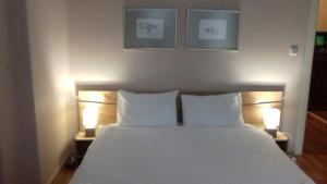 a bed with two white pillows and two lights at Julia Garden in Burgas City
