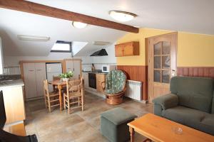a kitchen and living room with a couch and a table at Apartaments Cal Noi in Camprodon