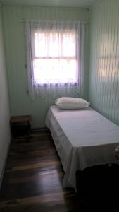 a small bedroom with a bed and a window at Casa Santos Dumont in Gramado +12 photos