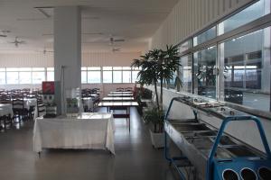 uma grande sala com mesas, cadeiras e janelas em David Plaza Hotel em Osasco