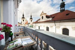 een balkon van een gebouw met een tafel met een fles wijn bij Royal Road Residence in Praag