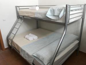 Casa Playa Gandia Centro I في غانديا: سريرين بطابقين مع مناشف عليهم