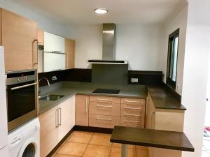 Casa Playa Gandia Centro I في غانديا: مطبخ كبير مع حوض وغسالة صحون