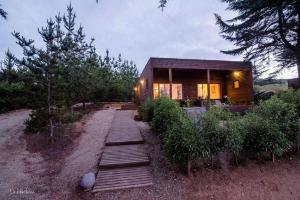 a wooden path leading to a small house at Cabañas Cantomar in Pichilemu