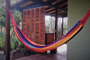 a hammock hanging from a porch with a deck at Jamanota Happy View in Boton