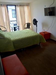 a bedroom with a bed with a green comforter at Aparta estudio en Ibagué in Ibagué