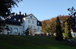 a large white building with a clock on it at Baldersnäs Herrgård in Dals Långed