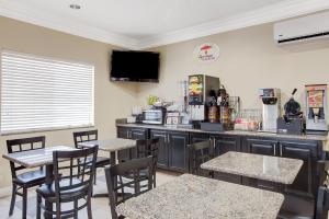 Un restaurante con mesas y sillas y un mostrador. en Super 8 by Wyndham Houston North I-45, en Houston