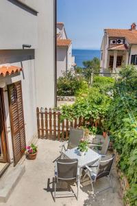 a patio with a table and chairs and the ocean at Apartment Budinic in Mali Lošinj