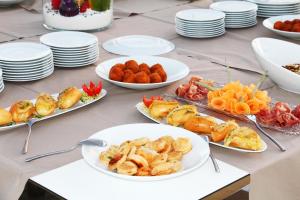 une table avec des assiettes de denrées alimentaires et des assiettes de denrées alimentaires dans l'établissement Resort Il Mulino, à Favignana