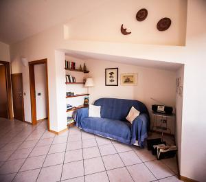una sala de estar con un sofá azul en una habitación en Bosa Apartments "Attic On The River", en Bosa
