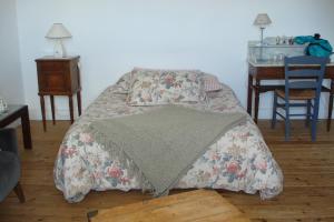 ein Schlafzimmer mit einem Bett mit einer Decke darauf in der Unterkunft Maison d'Hôtes Augès in Tréguier
