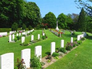 a cemetery with white fences and flowers in the grass at Ypres Ramparts House in Ypres