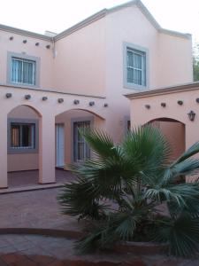 una casa con una palmera delante en Duplex Paraiso, en Villa Nueva