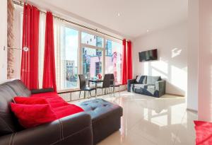 a living room with red curtains and a couch at hostelswidnicka24 in Wrocław