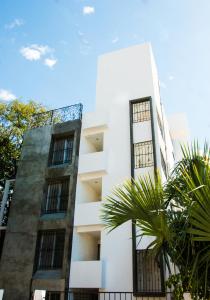 een wit gebouw met een palmboom ervoor bij Villa Antilope in Cancun