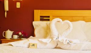 two towels shaped like swans sitting on a bed at Samay Wasi Hotel Chalhuanca in Chalhuanca