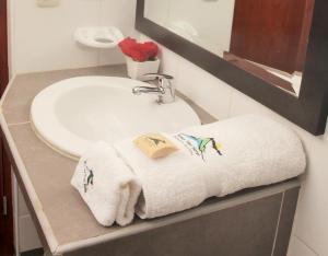 a bathroom sink with towels and a mirror at Samay Wasi Hotel Chalhuanca in Chalhuanca