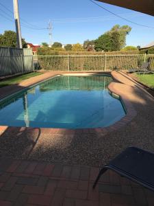 uma piscina num quintal com uma cerca em The Kidman Wayside Inn em Griffith