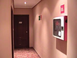 a hallway with a tv on the wall next to a door at Hotel Manises in Manises