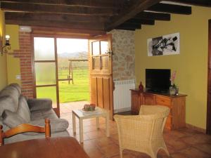 a living room with a couch and a television at Casa Rural El Jondrigu in Cangas de Onís