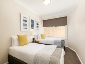 a bedroom with two beds and a window at BOUTIQUE STAYS - Sandy Breeze 1 in Sandringham