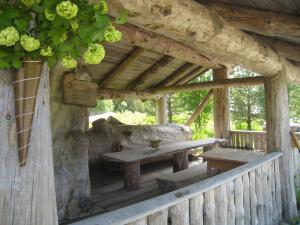 une terrasse couverte en bois avec une table et des bancs en bois dans l'établissement Saga Trollheimen Hotel, à Rindal