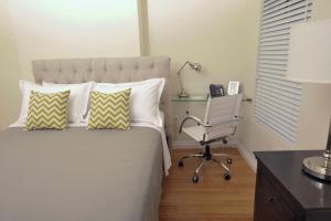 a bedroom with a bed with a desk and a chair at Bricco Suites in Boston