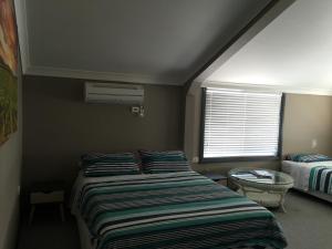 a small bedroom with a bed and a window at Cottage in the Country in Tumut