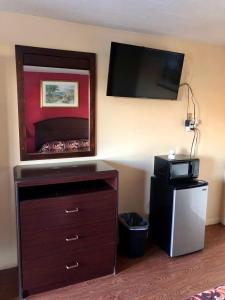 a room with a dresser and a tv on the wall at Cajun Inn Motel in Galliano +15 photos