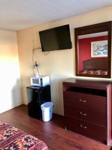 een hotelkamer met een bed, een dressoir en een spiegel bij Cajun Inn Motel in Galliano
