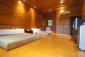 a bedroom with two beds and a flat screen tv at Bao Kang Flower Farm in Nanzhuang