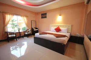 a bedroom with a bed and a dining room with a table at Windsor Resort in Lop Buri