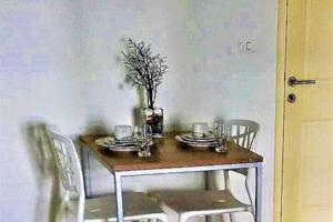 - une table à manger avec des assiettes et un vase dans l'établissement Baan Peang Ploen, à Hua Hin