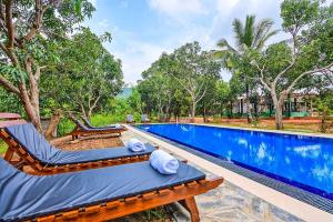 a resort swimming pool with a chaise lounge next to a resort at Dambulla Hills Resort in Dambulla