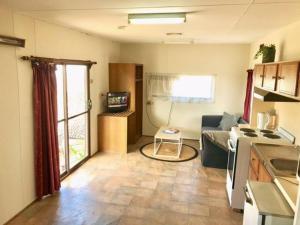 a kitchen and living room with a couch and a table at Cute Private Studio Flat with AIRCON! in Hay