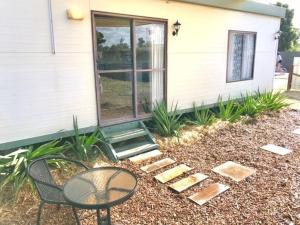 a patio with a table and a chair in front of a house at Cute Private Studio Flat with AIRCON! in Hay
