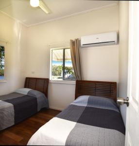 two beds in a room with a window at Absolute Waterfront in Brisbane