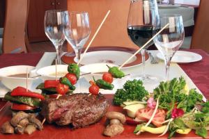 a table with a plate of food and wine glasses at Hotel Clipper - EL DELFÍN VERDE RESORTS - Platja de Pals in Torroella de Montgrí