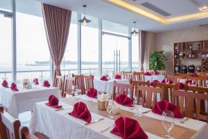 a restaurant with tables and chairs with red napkins at Vinh Hoang Hotel in Dong Hoi