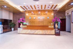 a wine tasting booth in a lobby with flowers at Vinh Hoang Hotel in Dong Hoi