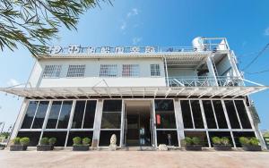 a white building with a sign on top of it at Kenting 213 Homestay in Hengchun