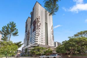 ein hohes Gebäude mit davor geparkt in der Unterkunft Ivy and Eve Apartments by CLLIX in Brisbane