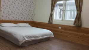 金寧鄉的住宿－鳳鳴民宿，一间卧室设有一张大床和一个窗户。