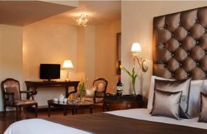 Habitación de hotel con cama y sala de estar. en Tagli Resort & Villas en Arachova