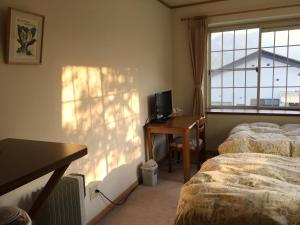 - une chambre avec 2 lits, un bureau et une fenêtre dans l'établissement Little Forest Inn Nikko, à Nikkō
